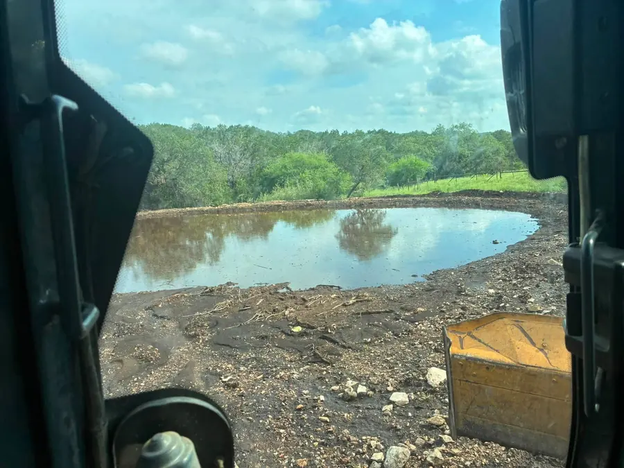 Fresh stock pond seen from the cab of a machine, with the bucket in view